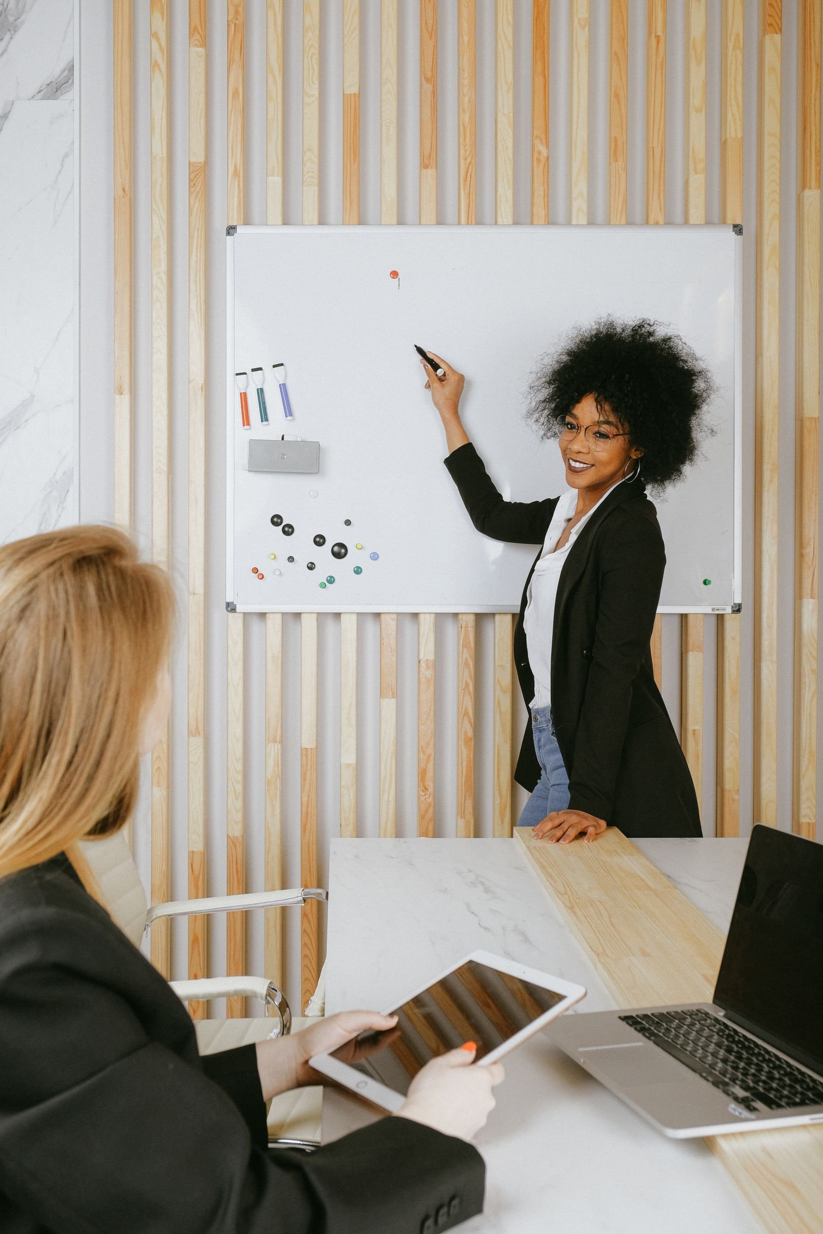 Confident woman leading a presentation at a whiteboard