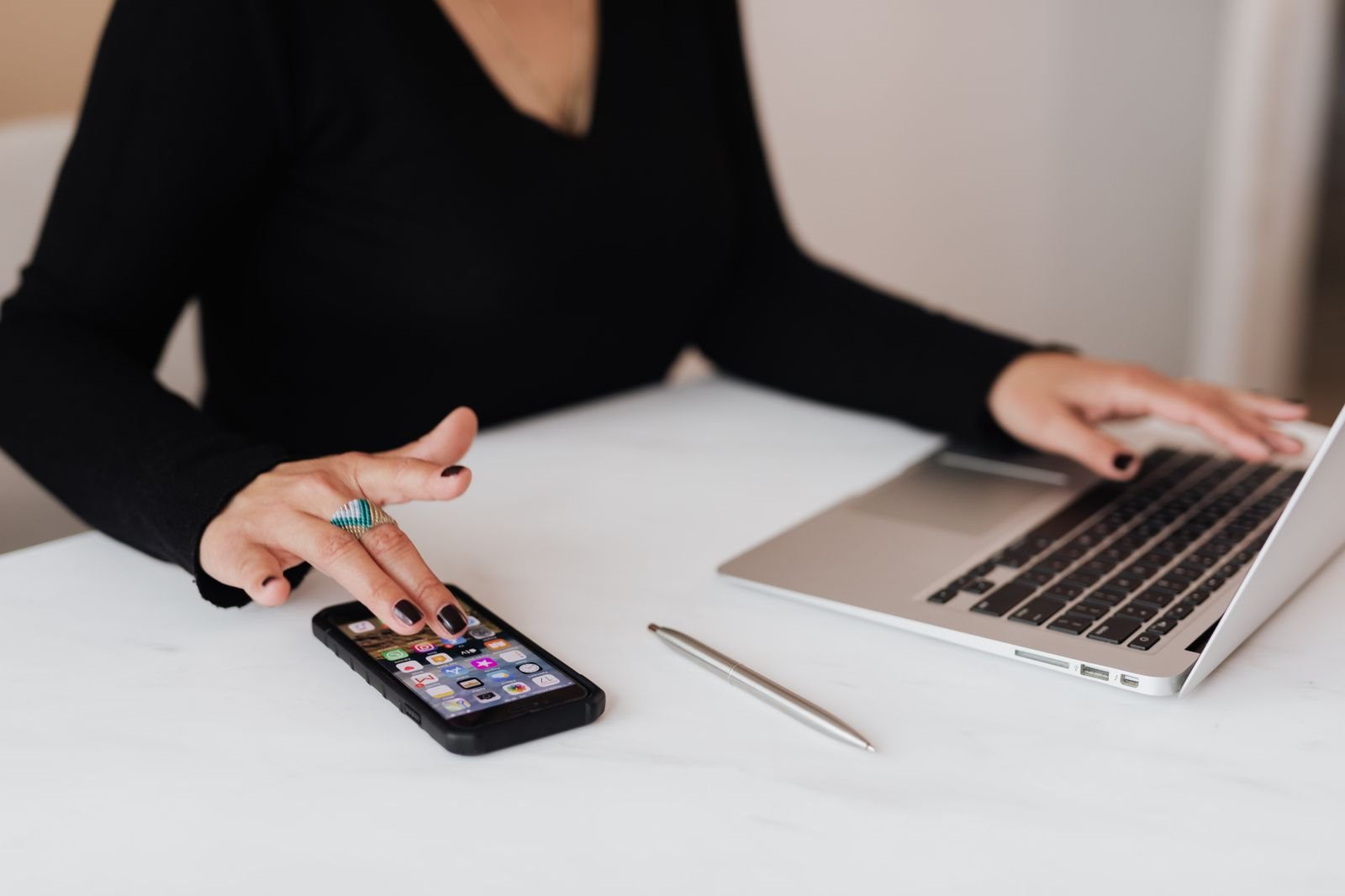 Social media manager using smartphone and laptop
