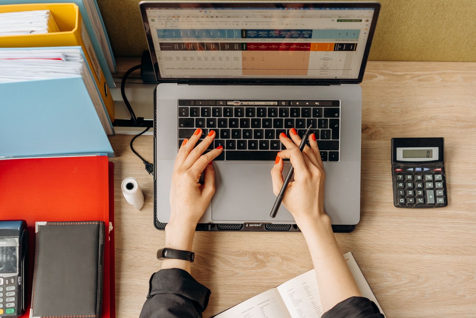 Hands typing on a laptop at an office desk
